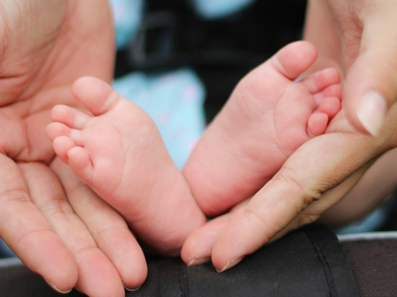 person holding baby feet symbolizing whole life and term life insurance